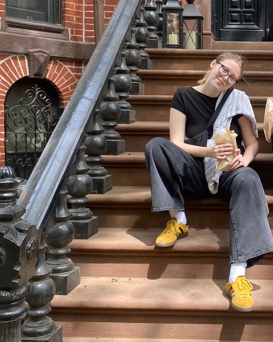 Katharina Gummich assise dans les escaliers d'une maison de Brooklyn pendant sa troisième année à l'étranger à l'université de Columbia.