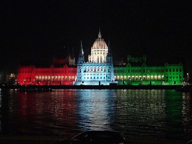 Hungarian Parliament Building at night lighted with the colors of Hungary