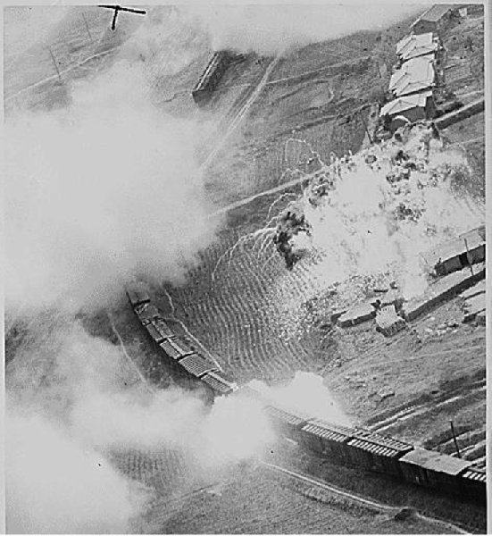  The tank of napalm dropped by Fifth Air Force B-26 Invader light bombers of the 452nd Bomb Wing (light) on this Red marshalling yard at Masen-ni, North Korea, has blended with a stockpile of supplies on a loading platform to from a fiery inferno, ca. 07/11/1951