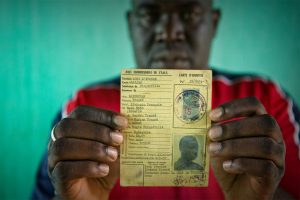 Oumar, who was at risk of statelessness, holds his father’s identity card from French colonial times. UNHCR/Hélène Caux