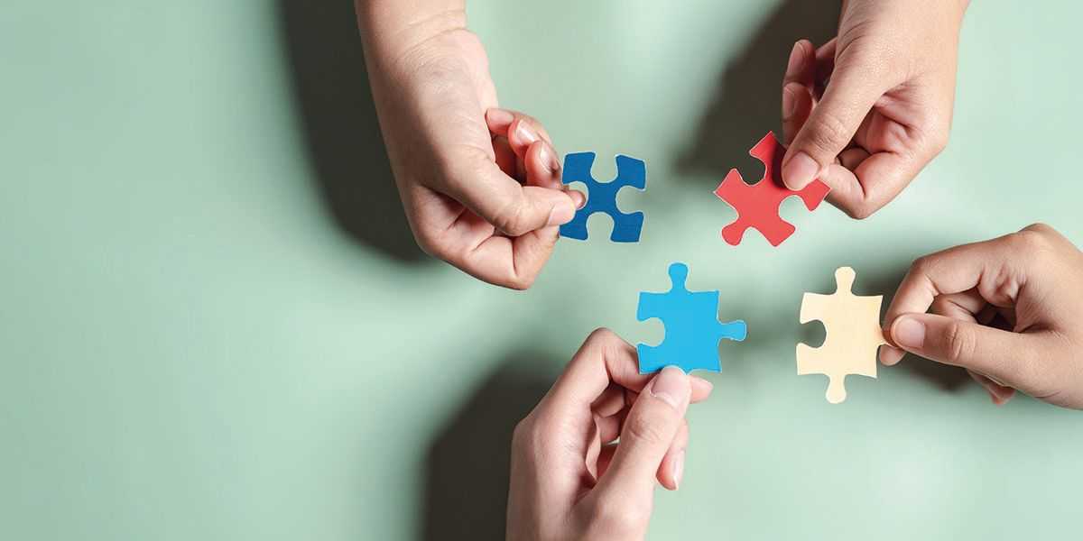Photo d'illustration représentant 4 mains tenant chacune une pièce de puzzle