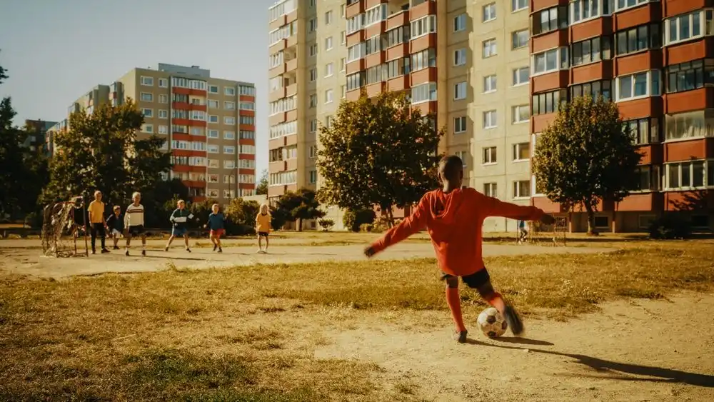 Young boy playing soccer in his neighbourhood.