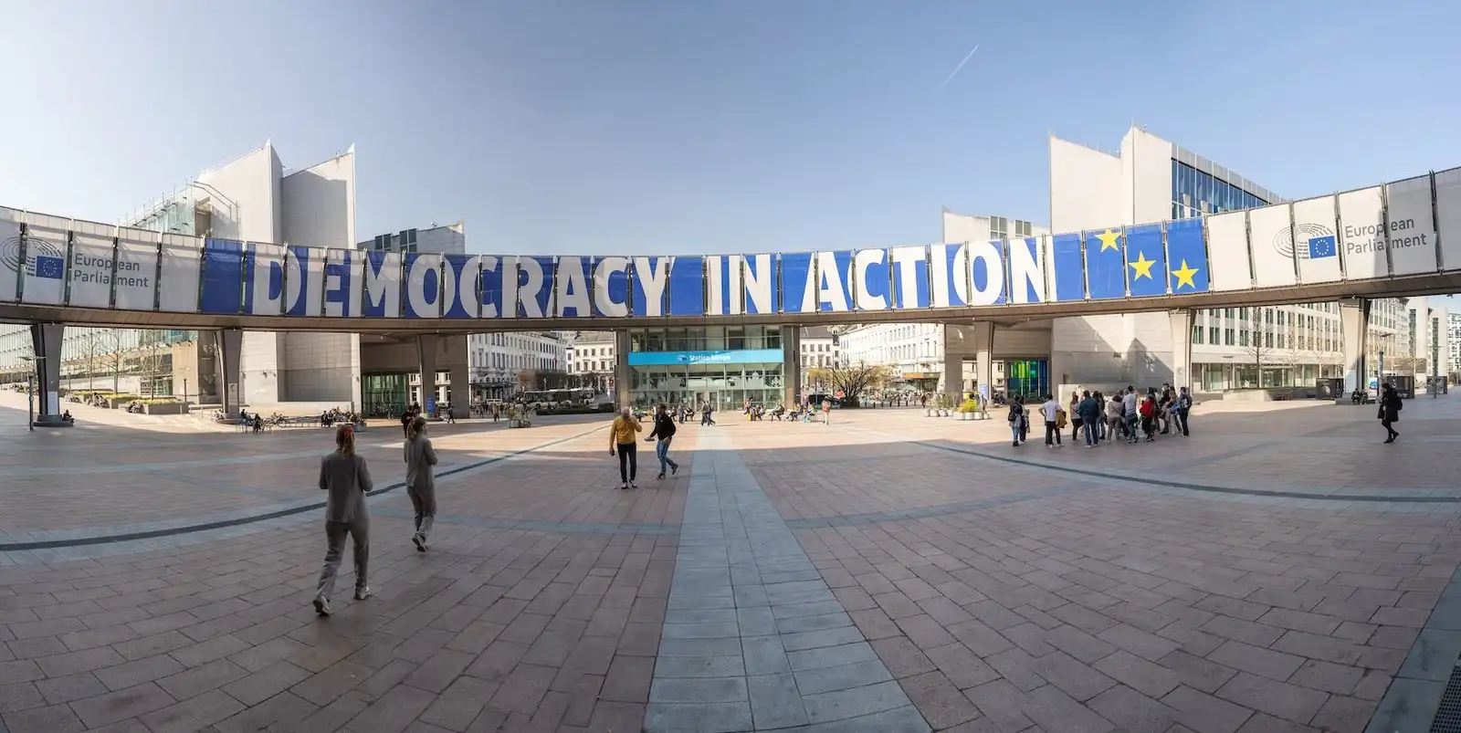 Brussels, Belgium; August 3, 2026—The European Parliament building in Brussels, with a “Democracy in Action” banner on the other side of its pedestrian bridge