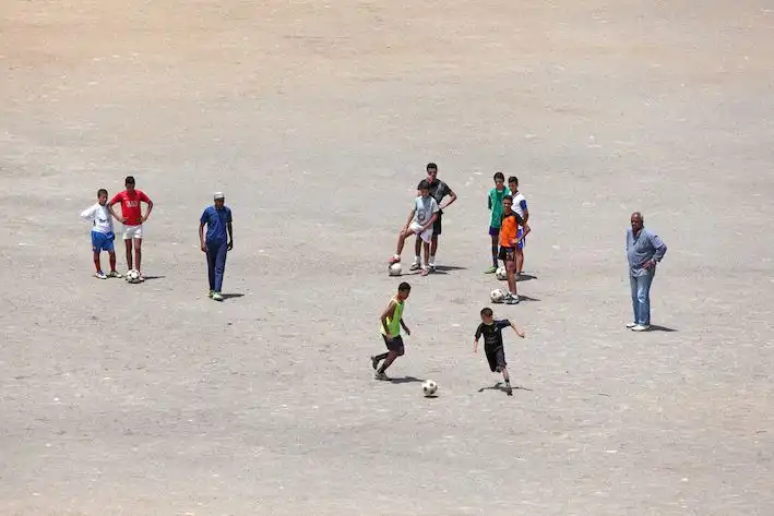 Young men playing football in Morocco, May 2021.
