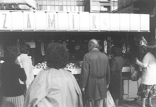 Devant l’étal d’une marchande de fruits et d’oignons, Łódź, 1984.