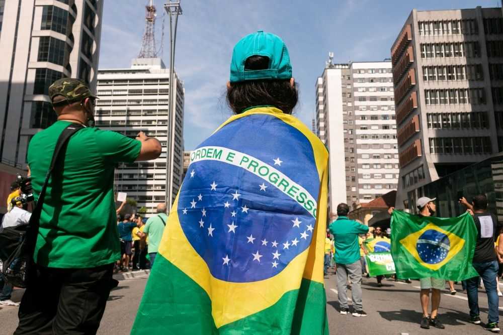 Vue de São Paulo avec un personnage qui porte le drapeau Brésilien sur le dos