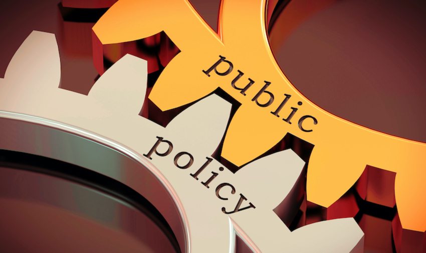 Two cogs fitting together on which public policy is written