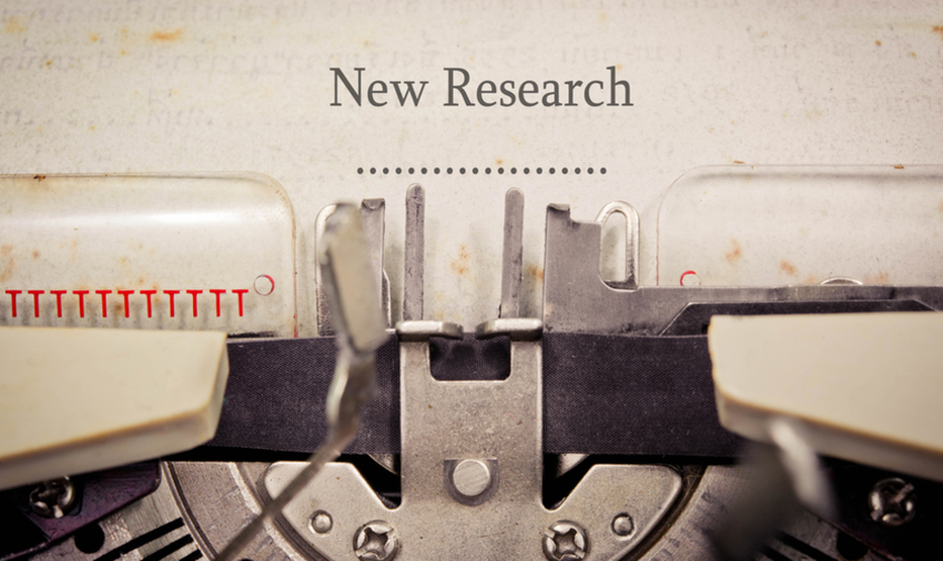 Paper in a typewriter on which it is written "New Research"