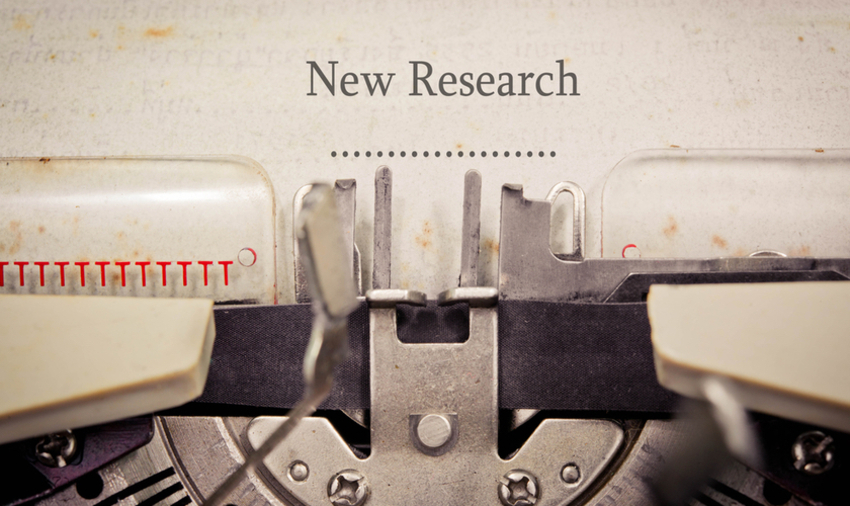 Paper in a typewriter on which it is written "New Research"