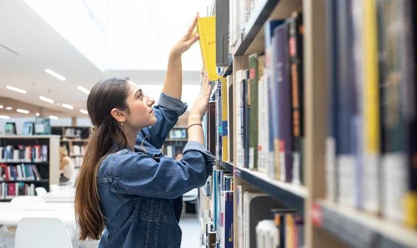 Une étudiante prenant un livre à la bibliothèque © Marta Nascimento/Sciences Po