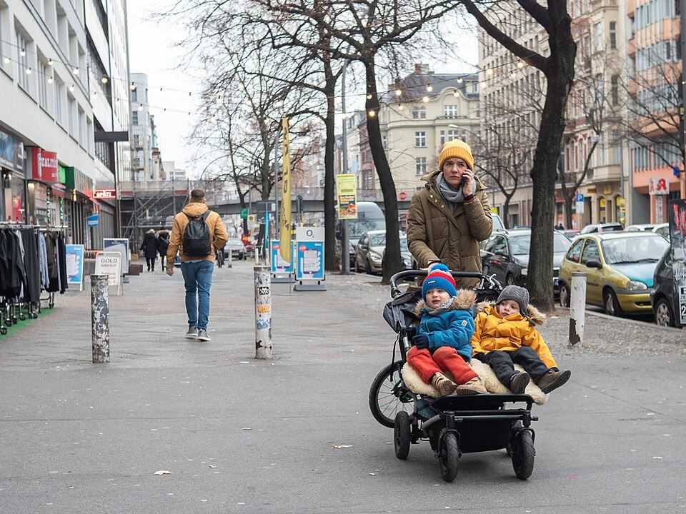 Une femme transporte des enfants en poussette