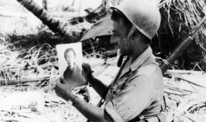 Private Sam Miller of Pennsylvania holds a photograph of a Japanese woman, found
