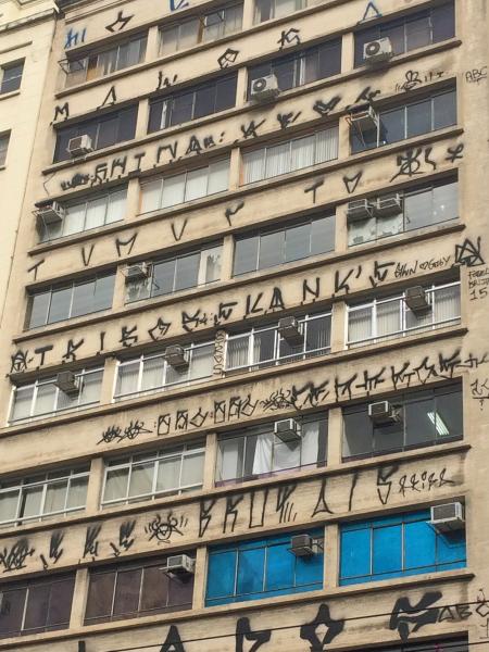  Pixo de São Paulo entre les fenêtres d’un immeuble d’habitation