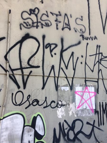 Pixo de São Paulo sur un mur gris