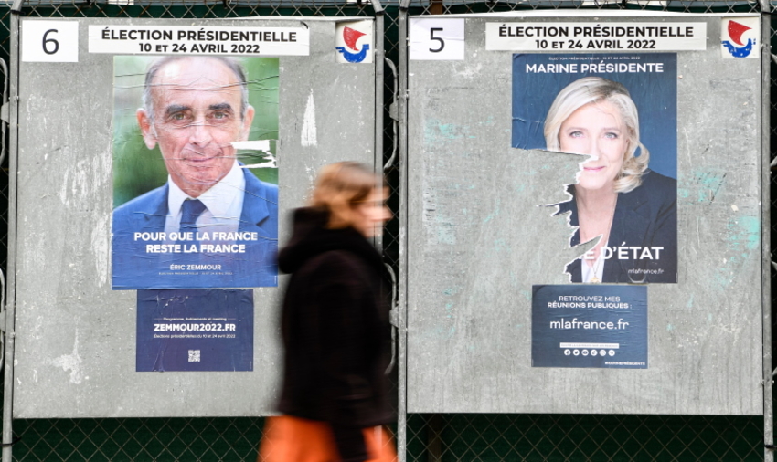 Une femme devant des affiches de campagne présidentielle 2022 © Victor Joly