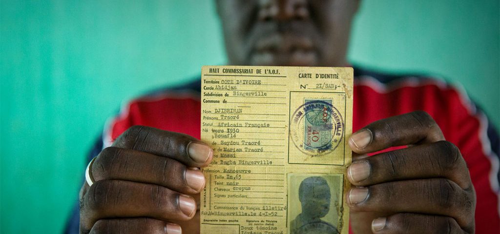 Oumar, who was at risk of statelessness, holds his father’s identity card from French colonial times. UNHCR/Hélène Caux