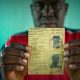 Oumar, who was at risk of statelessness, holds his father’s identity card from French colonial times. UNHCR/Hélène Caux