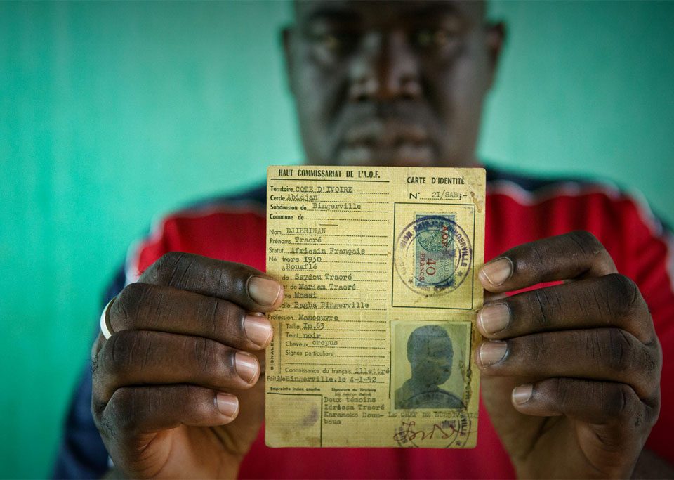 Oumar, who was at risk of statelessness, holds his father’s identity card from French colonial times. UNHCR/Hélène Caux