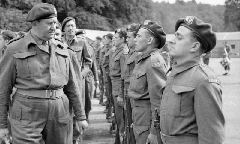 Lieutenant Colonel Charles Vaughan, Commandant Commando Depot, inspecting French troops during a parade to mark Bastille Day at Achnacarry in Scotland, 17 July 1943. Crédits : collections of the Imperial War Museums.