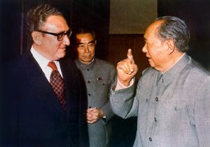 Henry Kissinger and Chairman Mao, with Zhou Enlai behind them in Beijing, early 70s. By Oliver Atkins (Jiang -original uploader on en wiki) [Public domain], via Wikimedia Commons