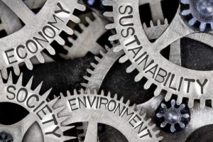 Macro photo of tooth wheel mechanism with SUSTAINABILITY, ECONOMY, SOCIETY and ENVIRONMENT words imprinted on metal surface by EtiAmmos via shutterstock