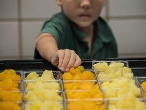 Child selecting fruit at a school lunch. USDA Photo by Lance Cheung.