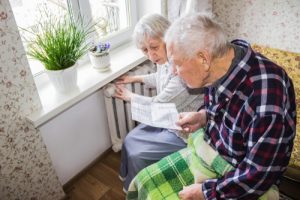 The senior woman holding gas bill in front of heating radiator. Payment for heating in winter. Crédits : Solarisys, Shutterstock 