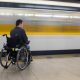 Le train passe devant une personne en fauteuil roulant. Crédits photo : Graceful Digital, Shutterstock