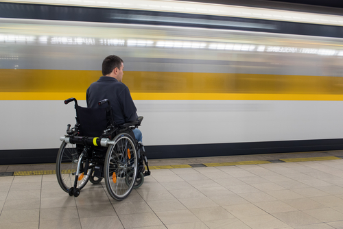 Le train passe devant une personne en fauteuil roulant. Crédits photo : Graceful Digital, Shutterstock